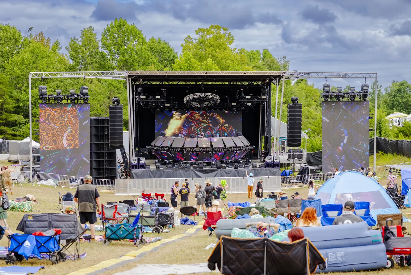 The mainstage in daylight as the crowd settles in on the hill at Jaceland